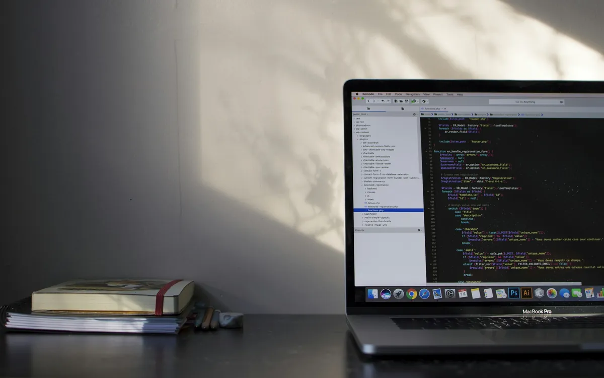 Laptop showing the code of a custom-built website on a desk in soft afternoon light - WordPress vs Custom website